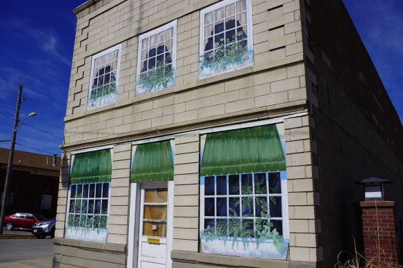 Boarded up windows painted in trompe l’oeil style.